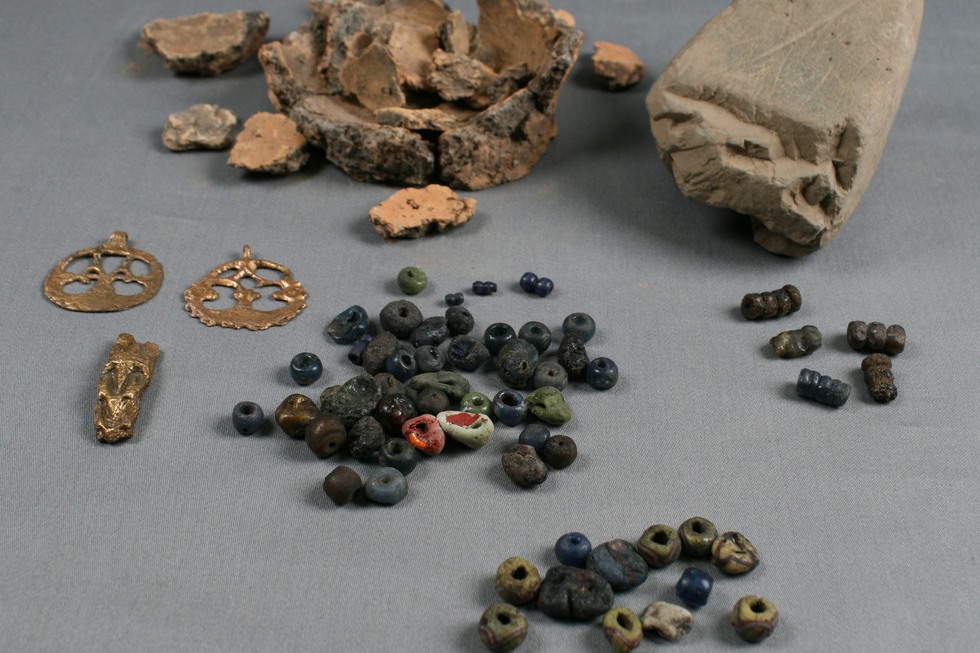 Arkeologiska fynd såsom pärlor och keramik.