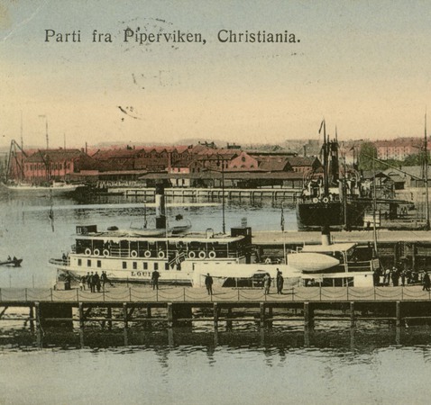 Vykort som visar båtar och hus i en hamn. Text: Parti fra Piperviken, Christiania