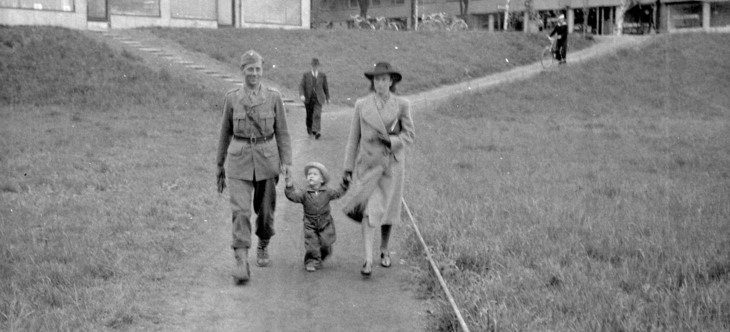 svartvit fotografi på man i uniform, barn, kvinna som går hand i hand