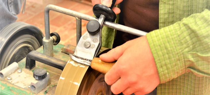 Närbild på händer som slipar en kniv