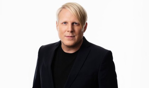 Blond man i svart tshirt och svart kavaj