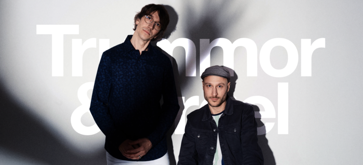 Två män framför vägg med texten Trummor & orgel