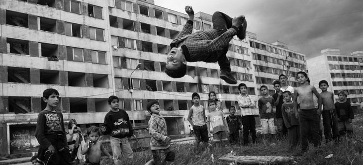 pojke hoppar i luft hus i bakgrund