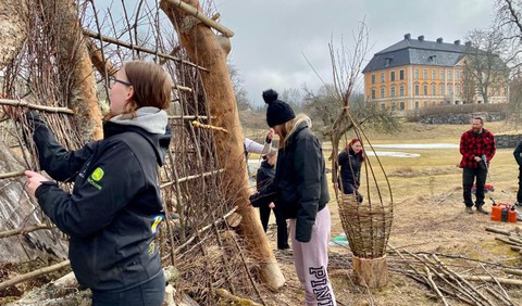 En grupp människor som står runt en ställning utomhus