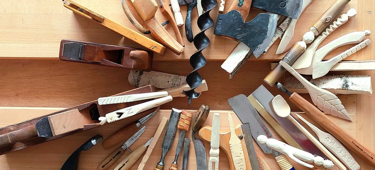  En cirkel av verktyg för träbearbetning, bland annat sågar, mejslar, hammare.