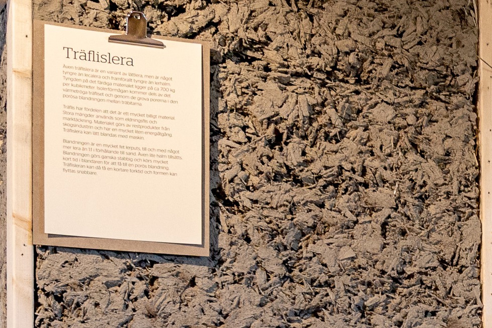 En vägg med träflislera i utställningen.