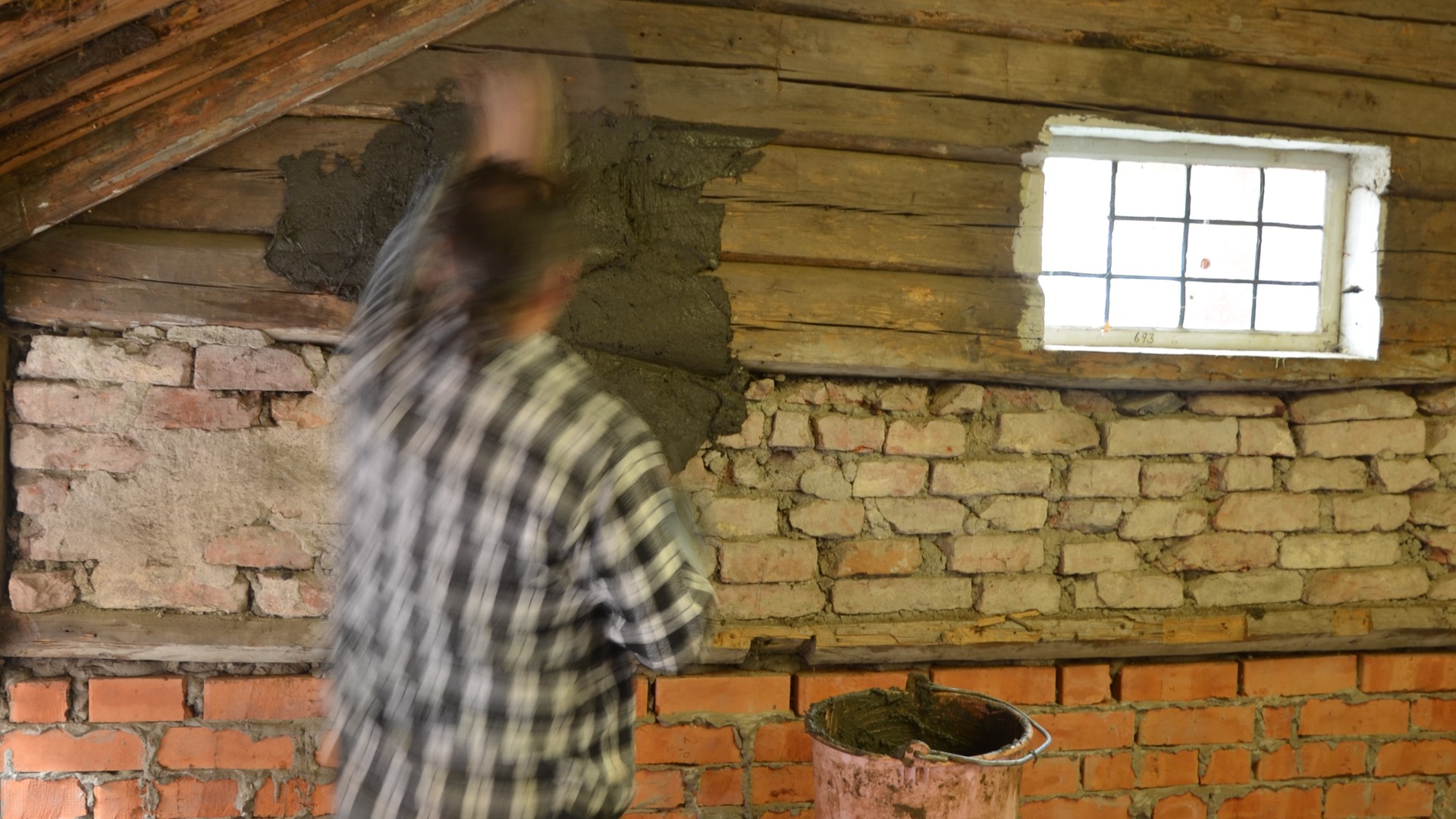 En man klär väggen med lerklin