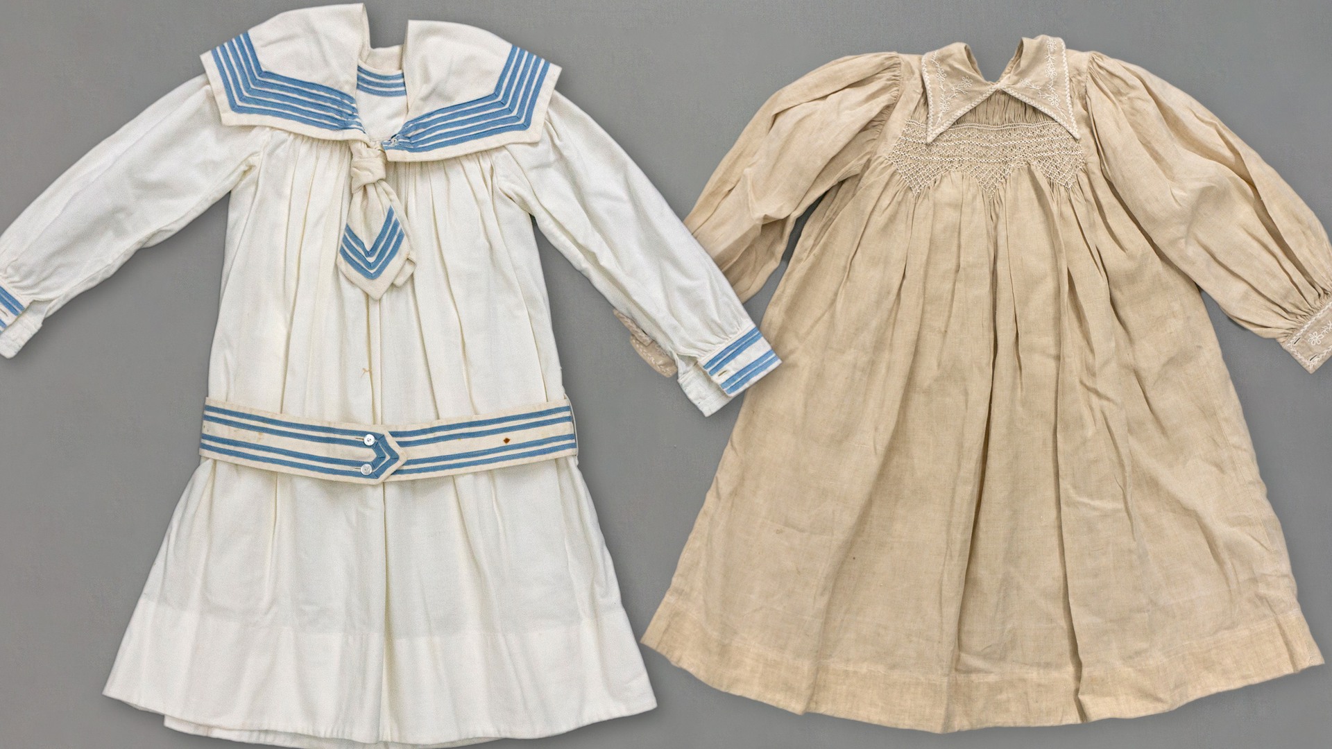 Barnkläder: En vit/blå sjömansklänning och en beige kolt.