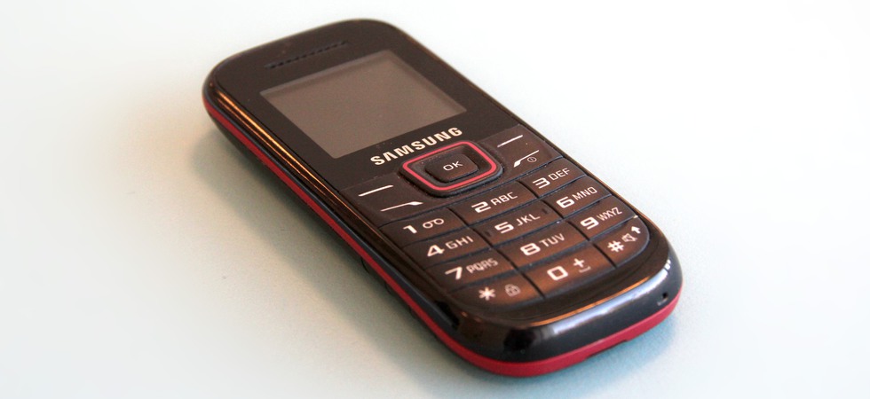 Äldre mobil med knappsats, märke Samsung.