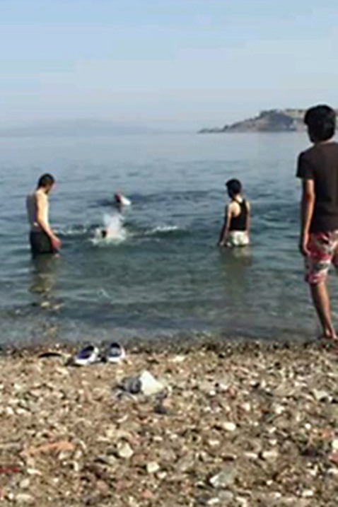 Ahmad, hans bror och två andra som också var på flykt badar vid stranden när de hade nått Grekland.