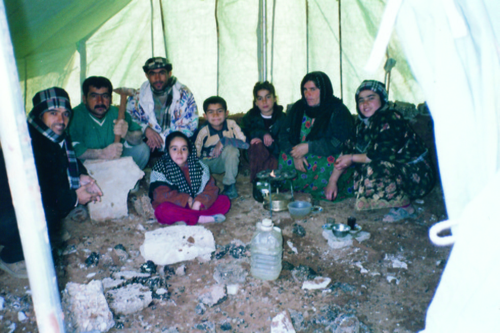 En grupp människor sitter och äter i ett tält