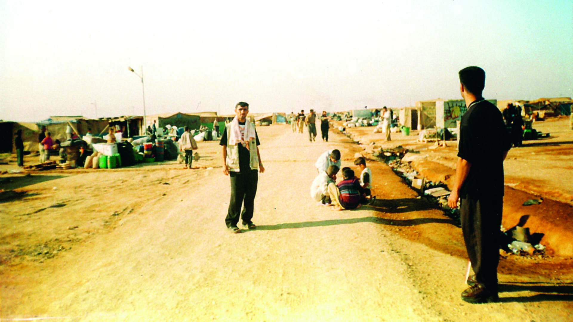 En man står på en väg i ett flyktingläger