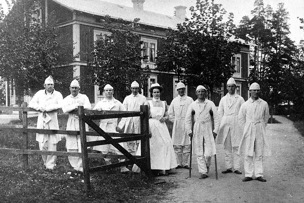 Sjukvårdspersonal och patienter framför sjukhuset.