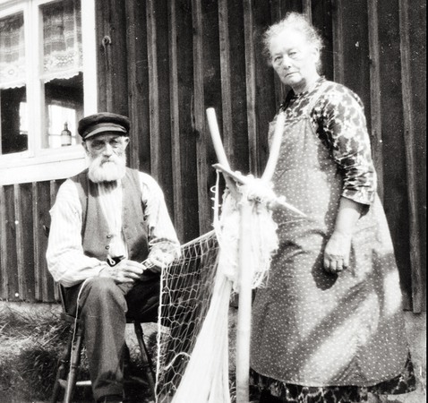 En äldre man och kvinna jobbar med ett fiskenät.