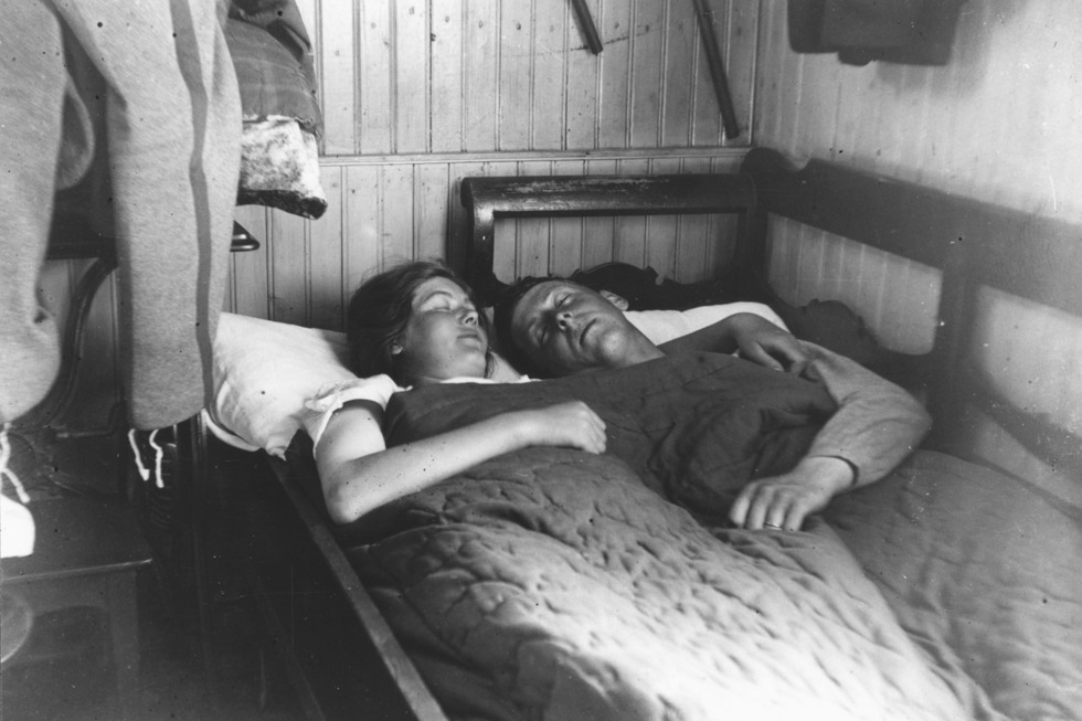 Ett par sover i en utdragssoffa.