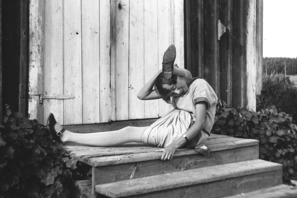 En ung kvinna göra akrobatiska konster på en trappa, ena benet bakom nacken.