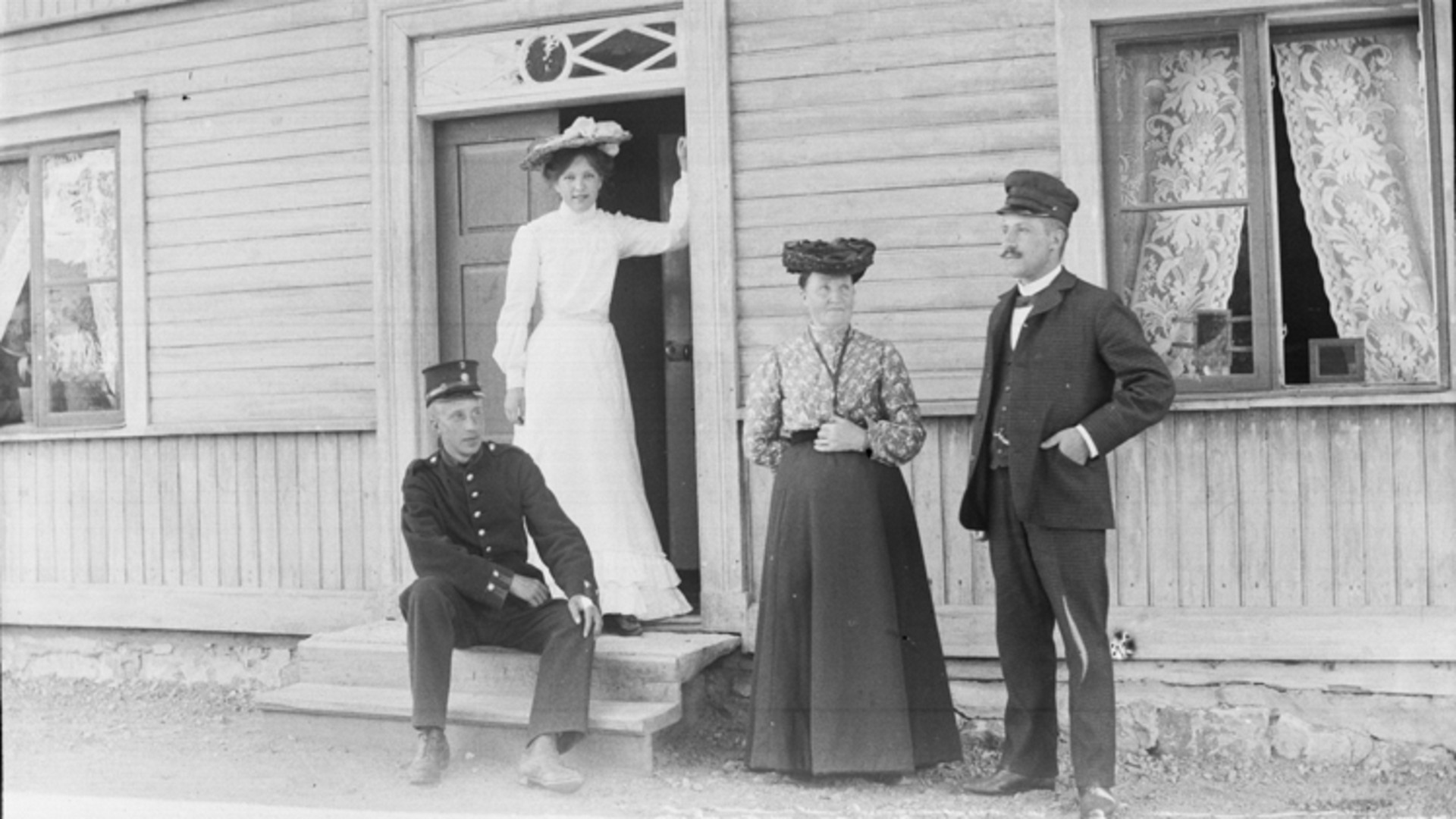 Två kvinnor och två män står framför ett hus.