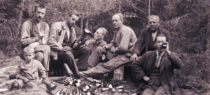 Män dricker öl i skog