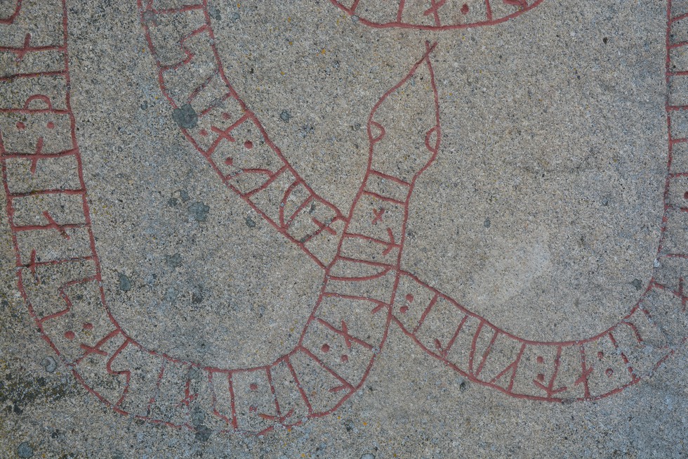Rödmålade runor slingrar sig som en orm.