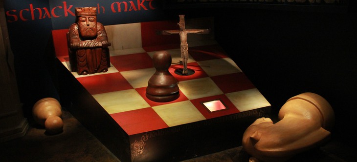 spelpjäser i trä på röd-vitt schackbräde