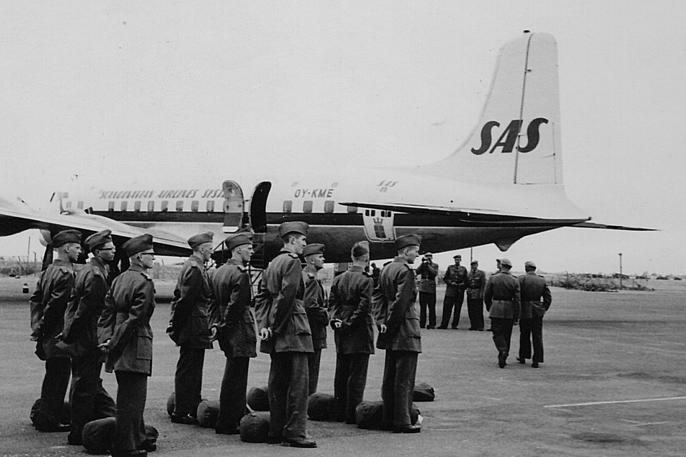 Soldater uppställda framför ett flygplan