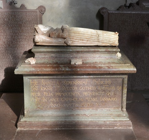 sarkofag av kalksten och alabaster, på toppen ligger en stenfigur i form av ett barn.