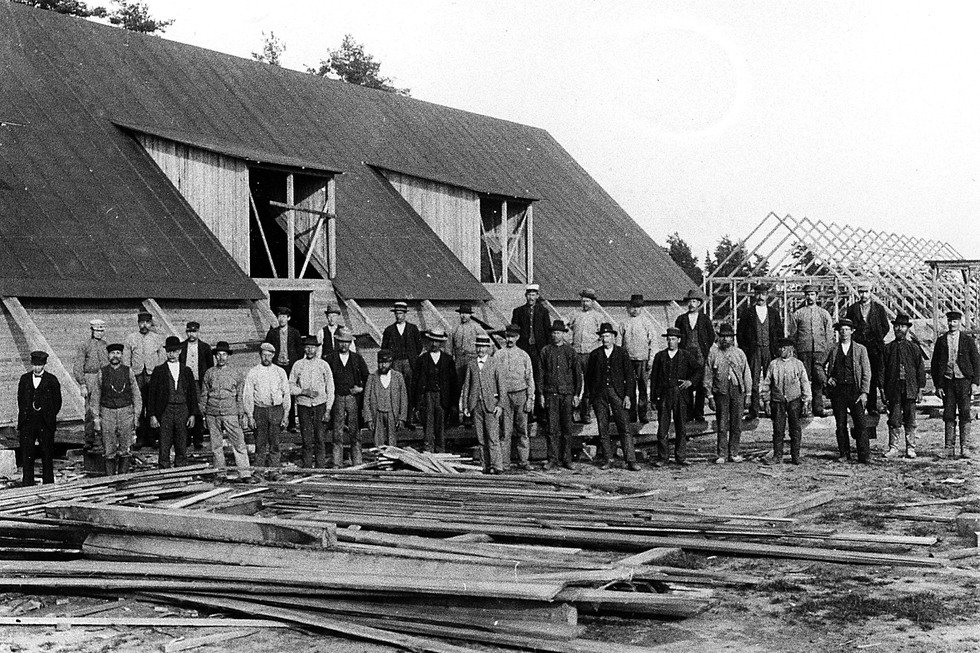 En stor grupp män bygger lägerhyddorna vid Malma hed.