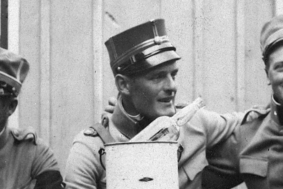 Tre soldater vid ett bord, framför dem ligger en flaska i en punschkylare.