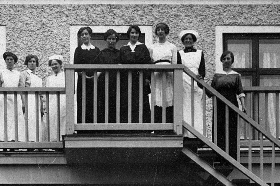 Kvinnor står på balkongen till ett värdshus.